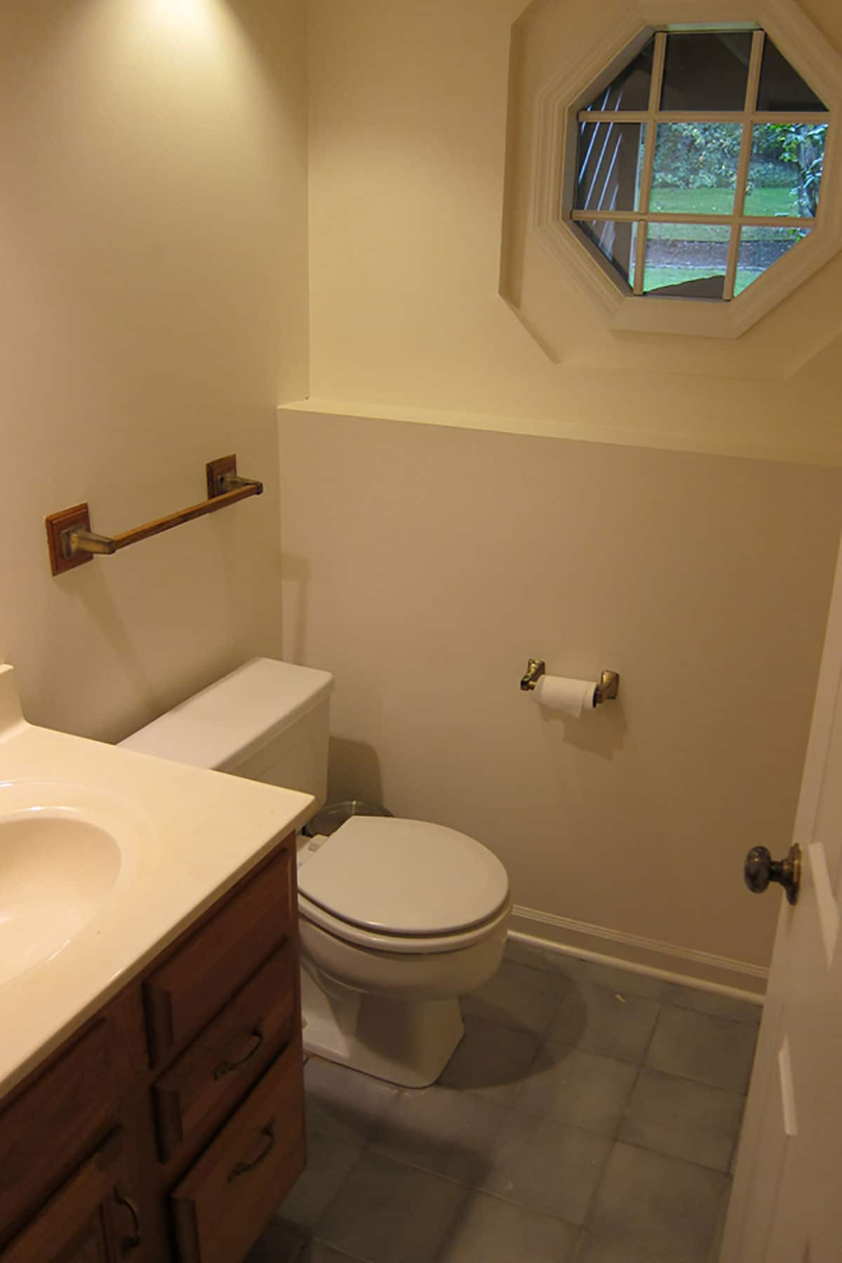 Basement bathroom renovation — outdated bathroom before shot with basic builder tile and vanity