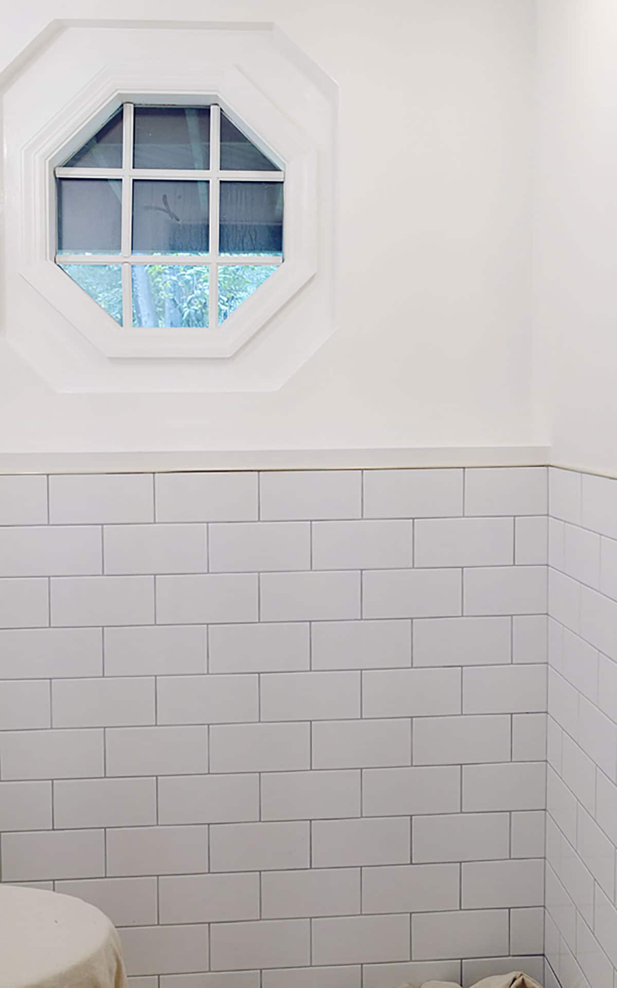 Laying the white subway tile in the bathroom renovation