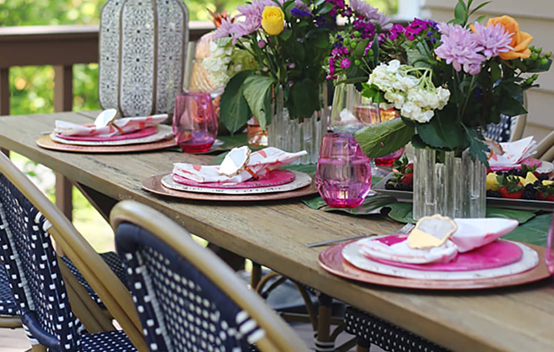 Outdoor Entertaining creating a colorful boho tablescape with pops of pink and blue. Outdoor patio furniture and decor