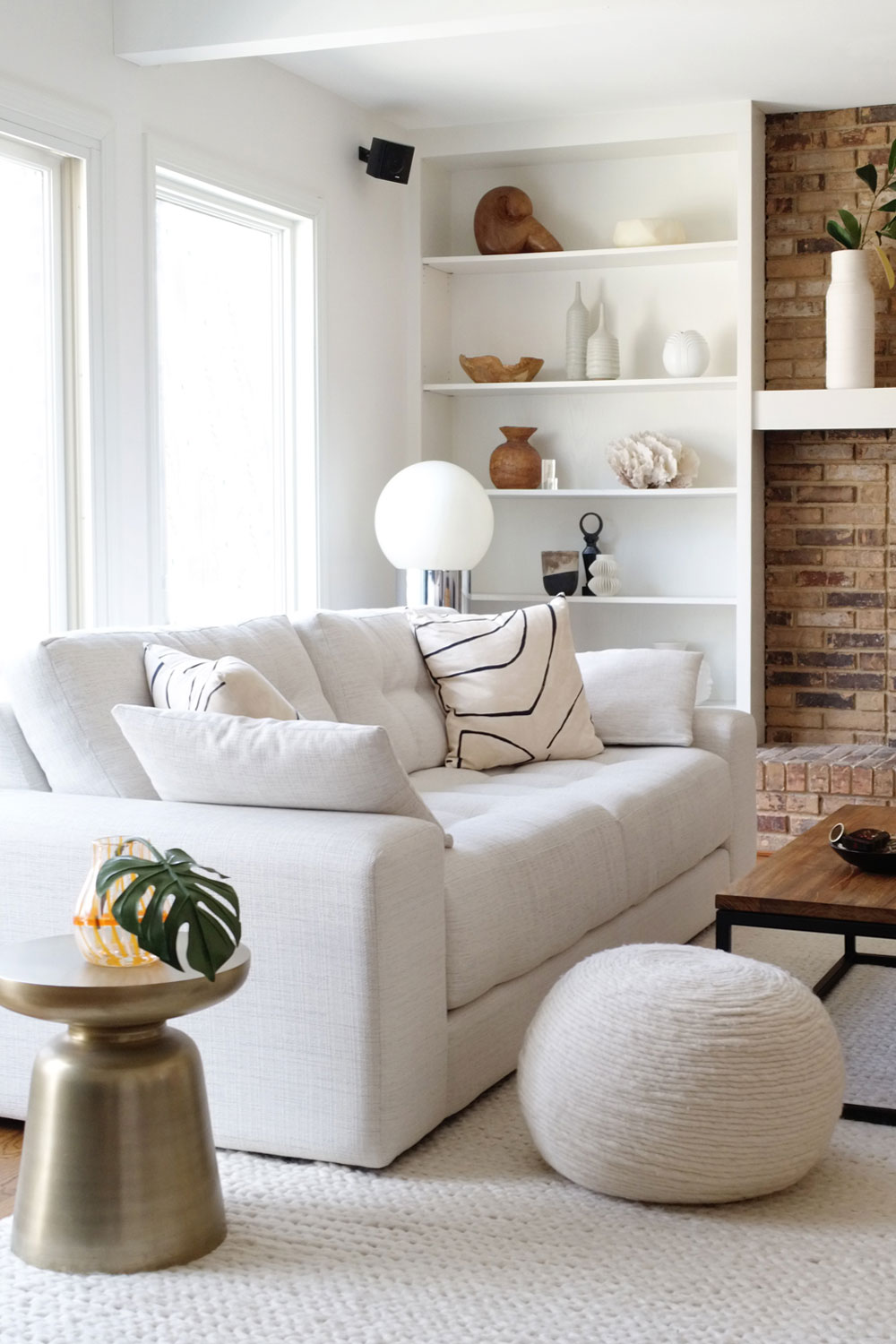 Farmhouse inspired living room with white sofa and white walls.
