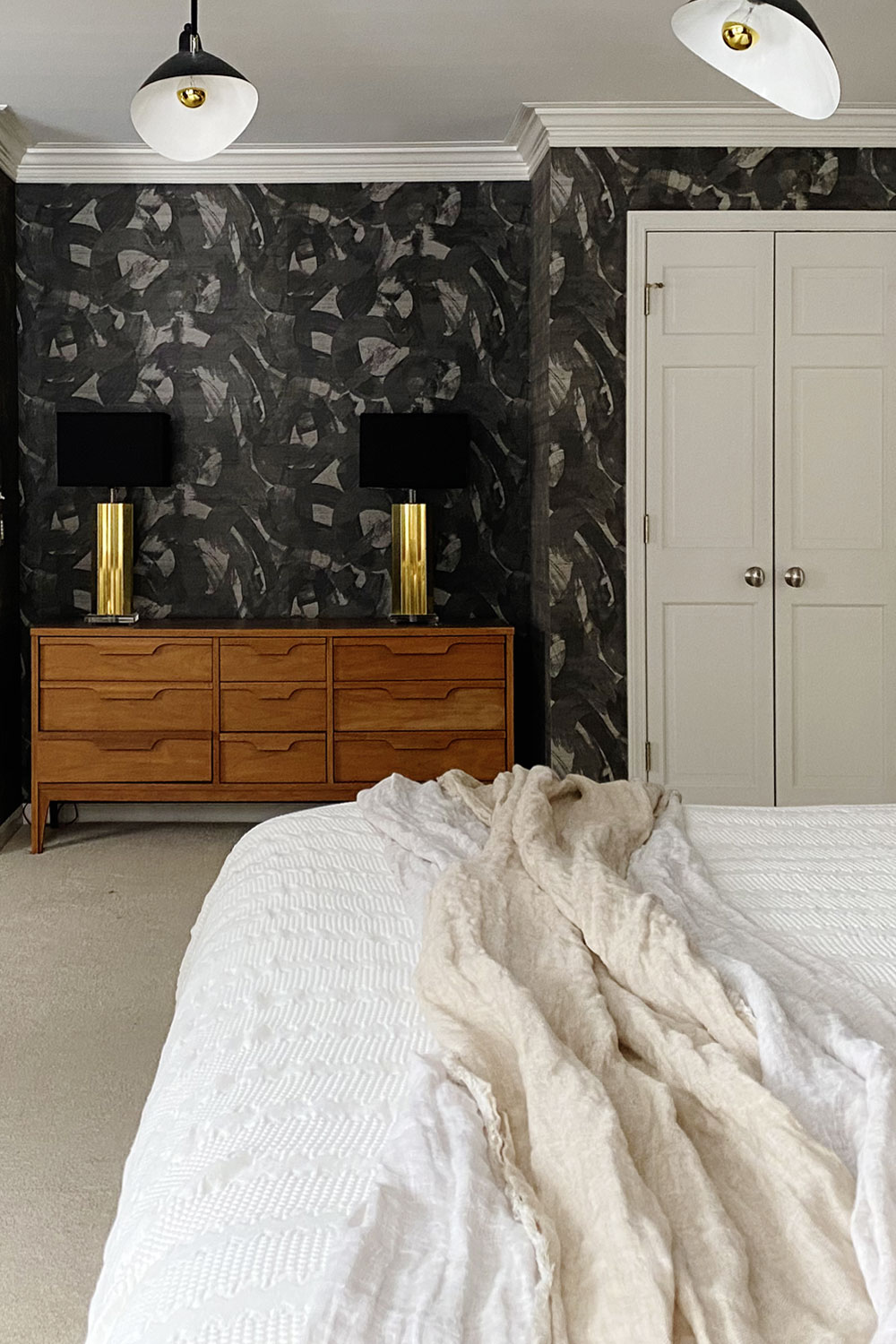 Black textured wallpaper in the bedroom with Phillips Jeffries Broad Strokes Scraffido Shadow. Luxury wallpaper in the primary bedroom to create a bold moody statement.