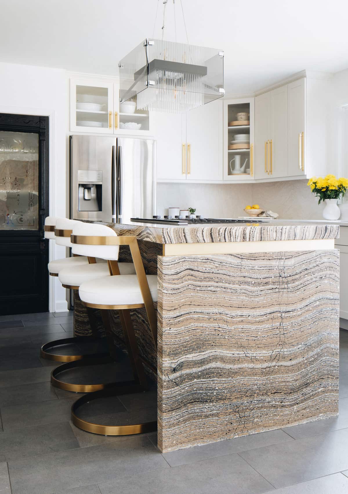 White Kitchens Are Not Out Here are 7 Ideas to Warm Them Up - Bold kitchen island design made a of quartz from Cambria warms this all white kitchen
