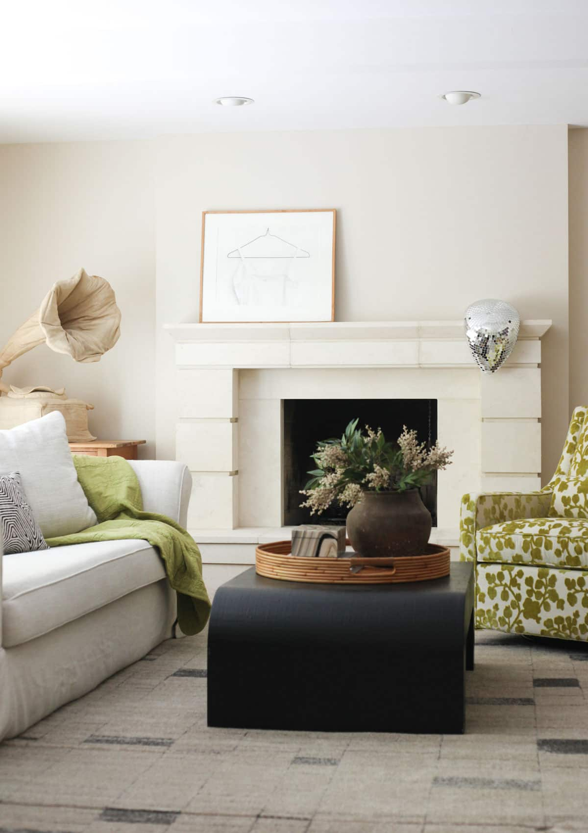 black coffee table in modern eclectic living room with limestone fireplace