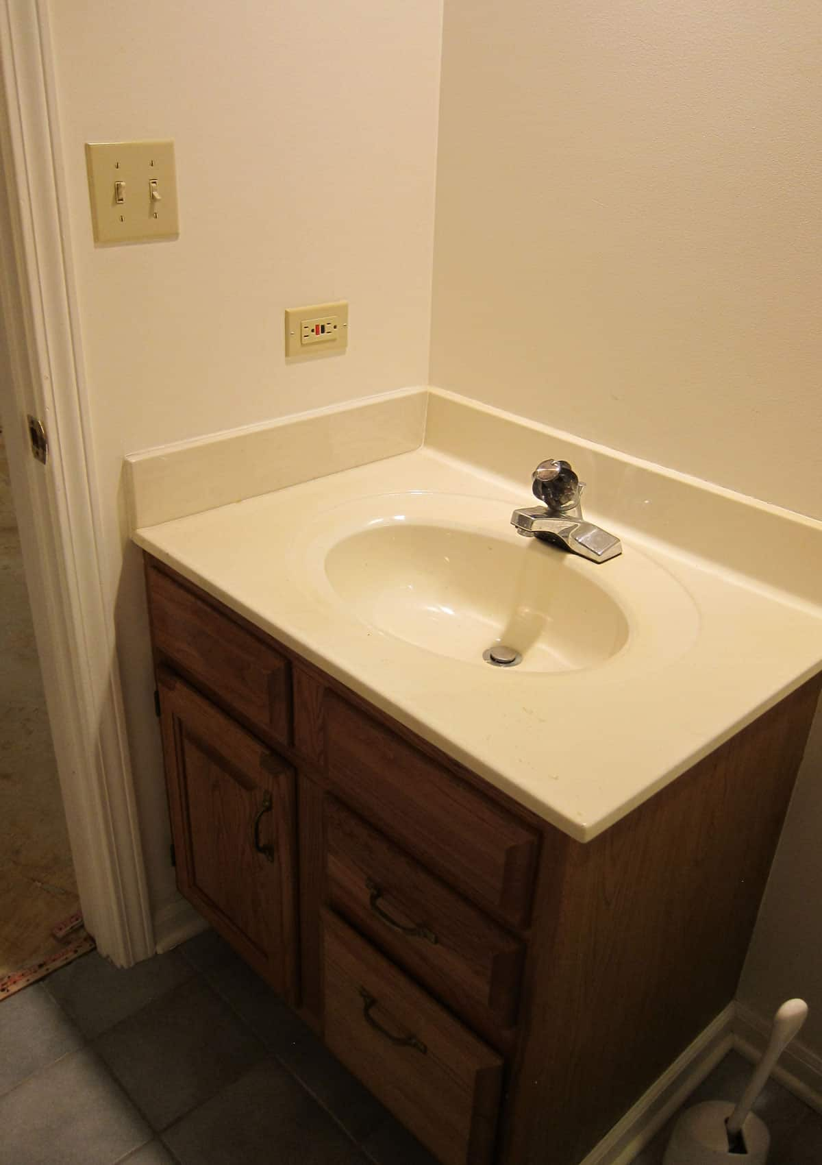 Black and White Bathroom Renovation Before and After - A before look at the outdated boring bathroom in our basement