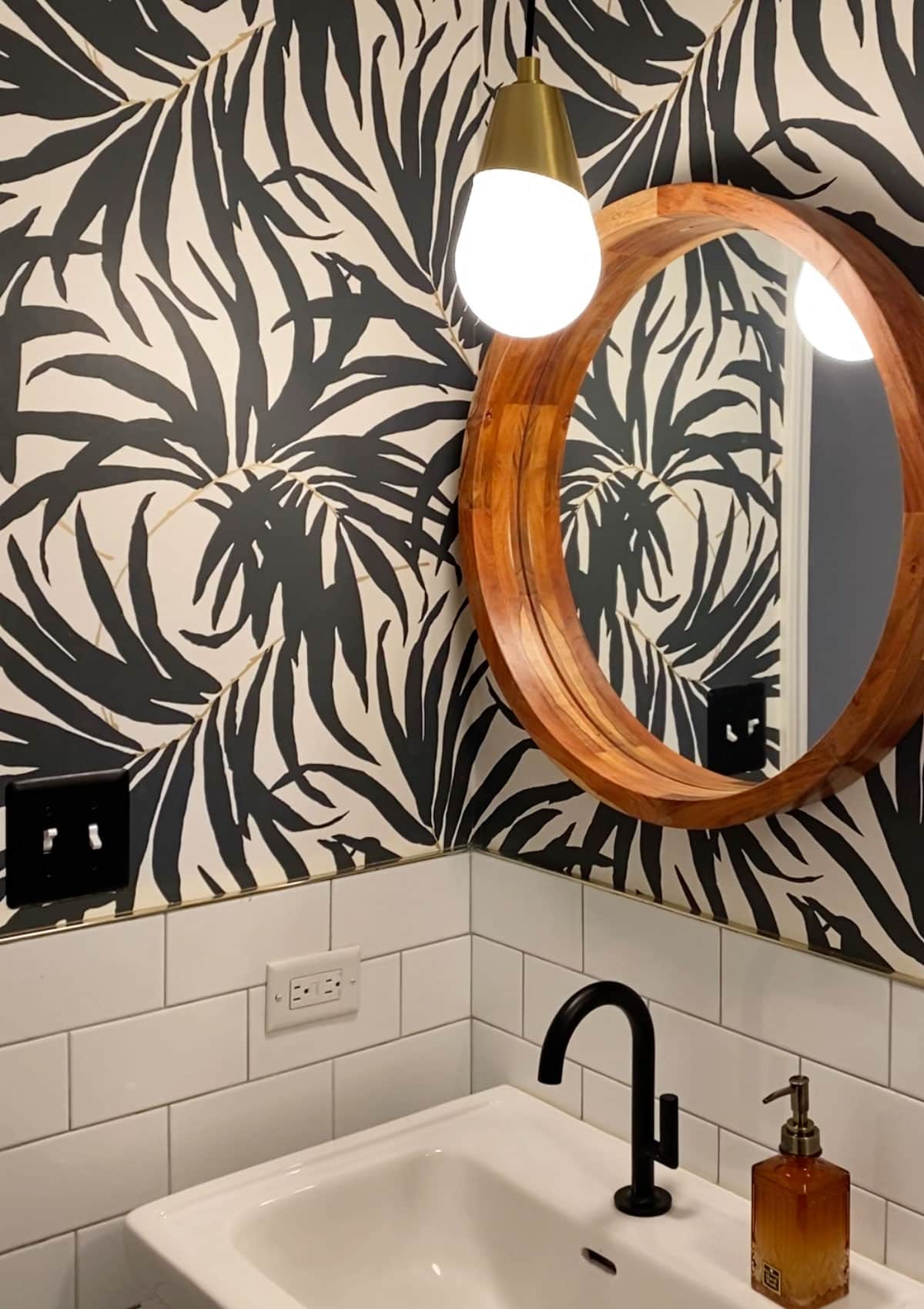 Black and White Bathroom Renovation Before and After - Transforming an old, outdated, boring bathroom and creating a stunning modern black and white bathroom with palm frond wallpaper and subway tile.