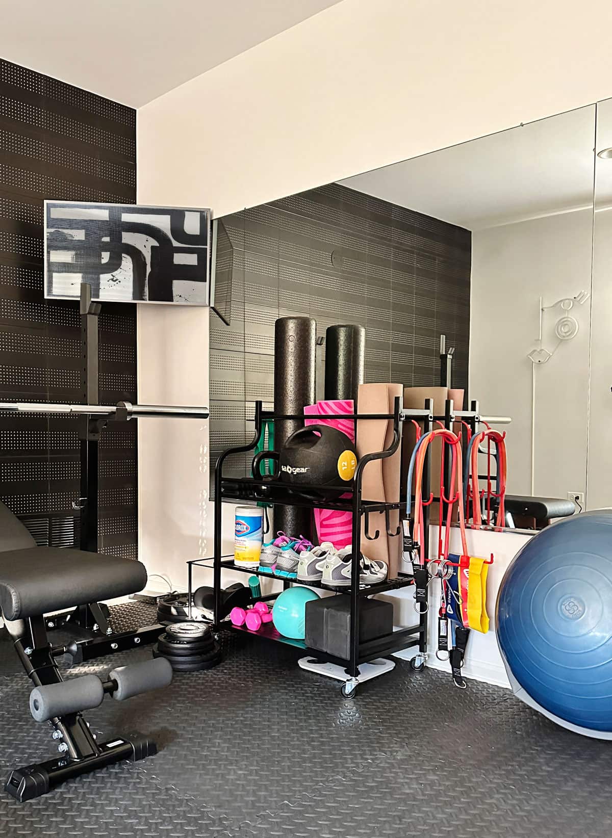 Mini Home Gym - Compact Ideas and Equipment This small space home gym storage rack keeps your yoga mat, weights, foam roller and resistance bands organized.